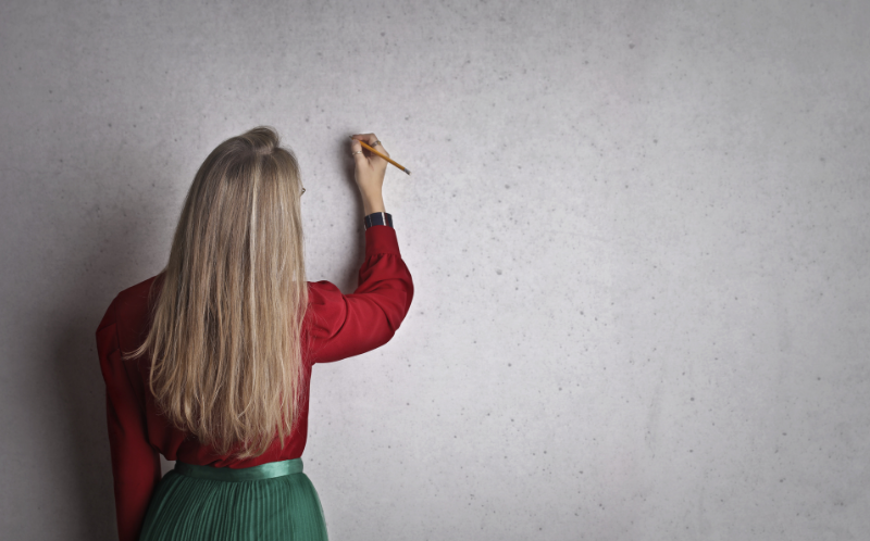 Chica escribiendo en una pizarra en blanco